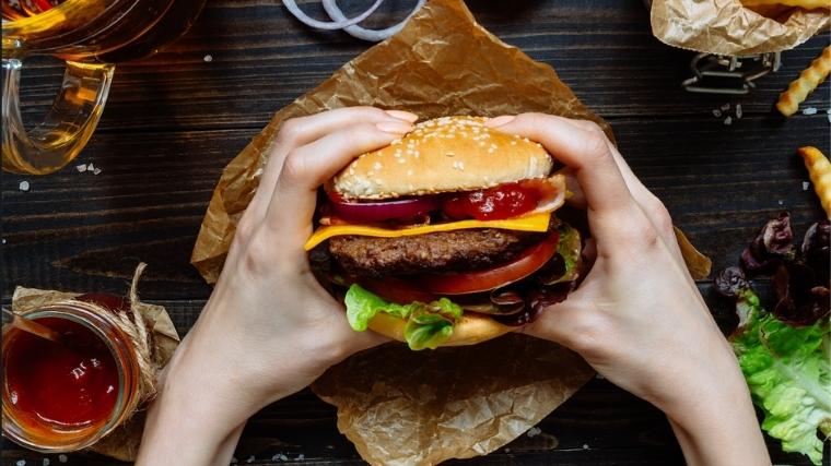 Person holding cheeseburger