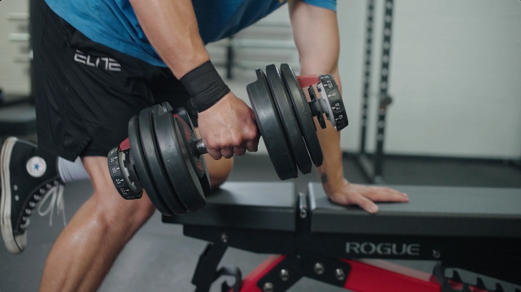 BarBend's Jake Herod performing dumbbell rows with the Selecttech 552 Adjustable Dumbbells.