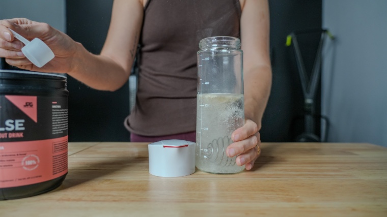 Our tester dumping a scoop of Legion Pulse Pre-Workout.