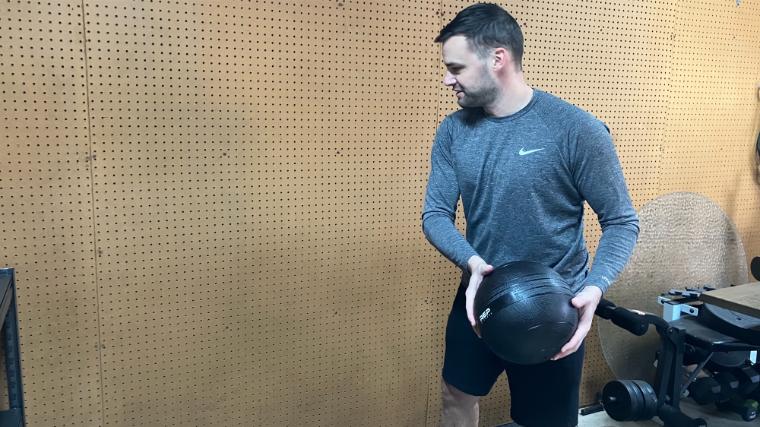 BarBend reviews writer Matt Cummings doing a wall toss with the REP Fitness Slam Ball.