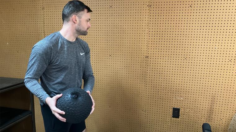 BarBend reviews writer Matt Cummings performing a wall toss with the Titan Fitness Slam Ball.